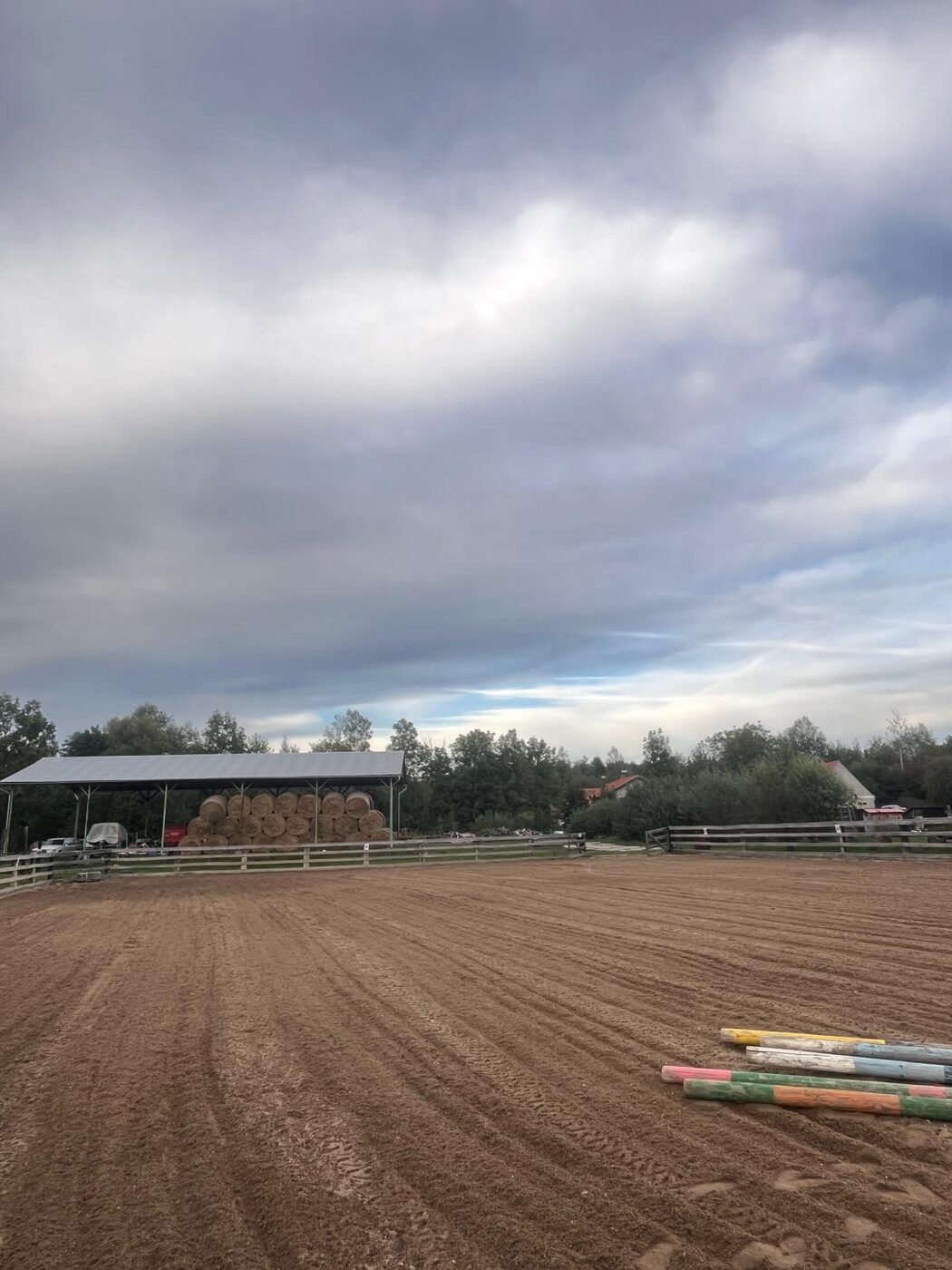 Písková jízdárna 20 × 40 m, v pozadí kryté seníky